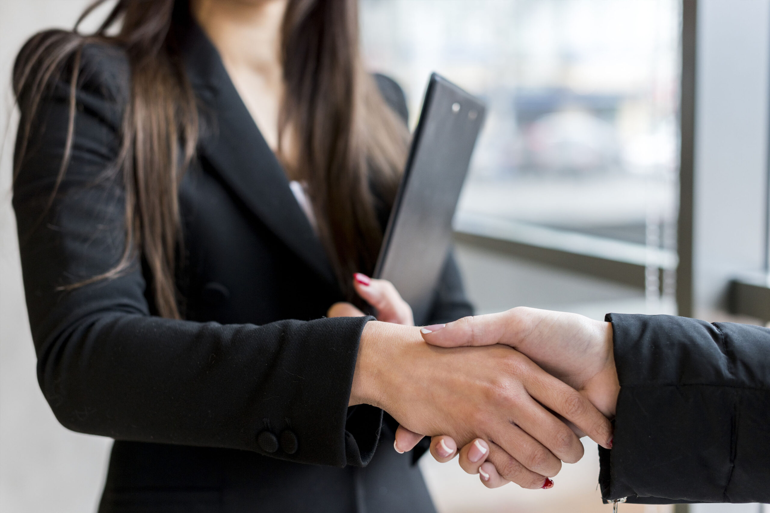 Blindfolded figure of Justice holding scales and a sword conceptual of the courts, judgement, law and order in a beam of light over a grey background with copy space