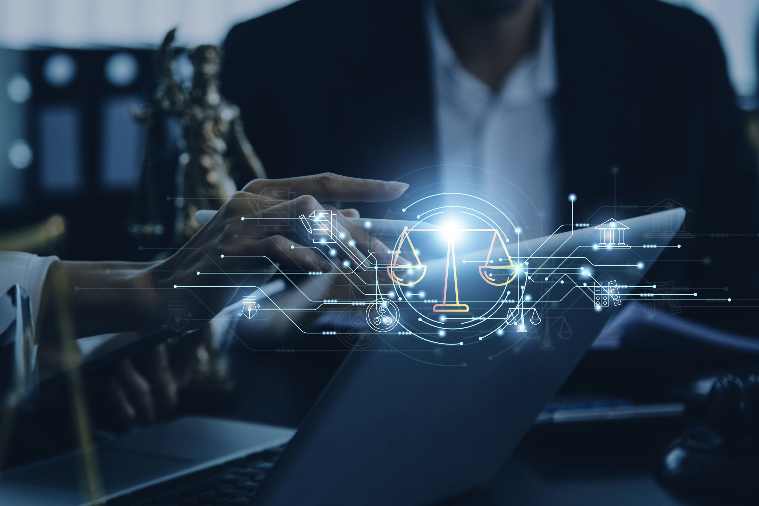 Blindfolded figure of Justice holding scales and a sword conceptual of the courts, judgement, law and order in a beam of light over a grey background with copy space