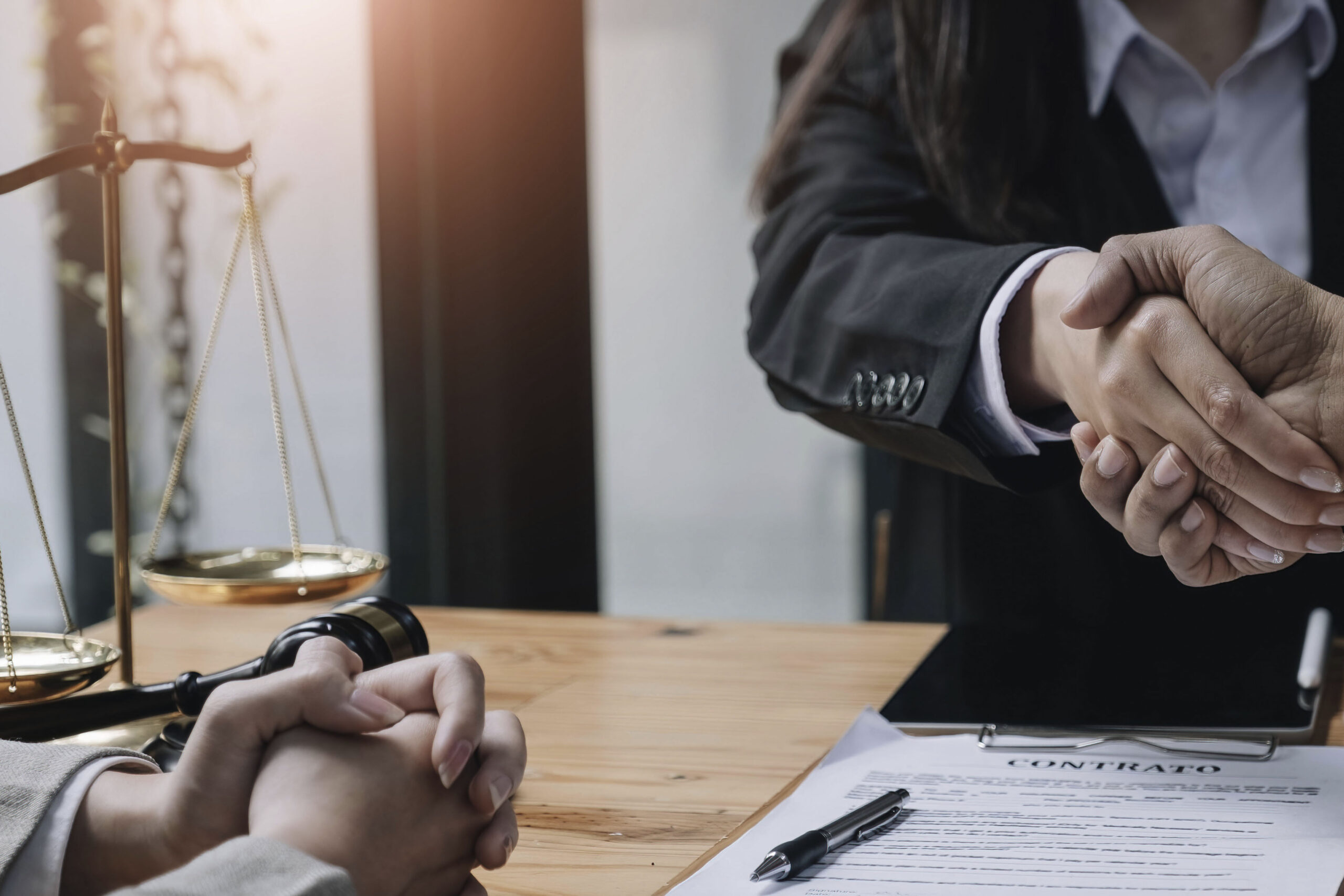 Blindfolded figure of Justice holding scales and a sword conceptual of the courts, judgement, law and order in a beam of light over a grey background with copy space